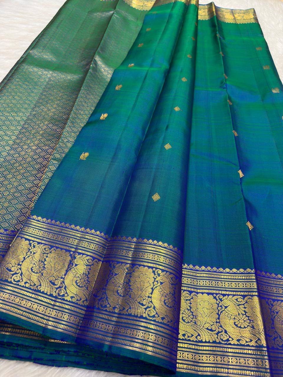 Peacock Blue, emerald green, royal blue and antique gold handwoven Kanchipuram butta silk saree, border zari detail, with gold zari detailing.