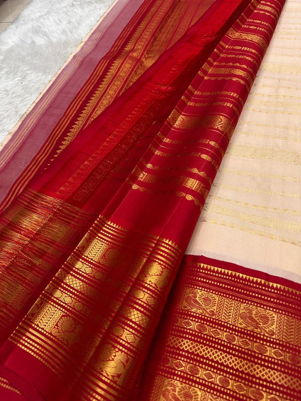 Warm ivory Vairaoosi pure silk Kanchipuram saree – Arakku red border with stacked zari ornament and peacock figures