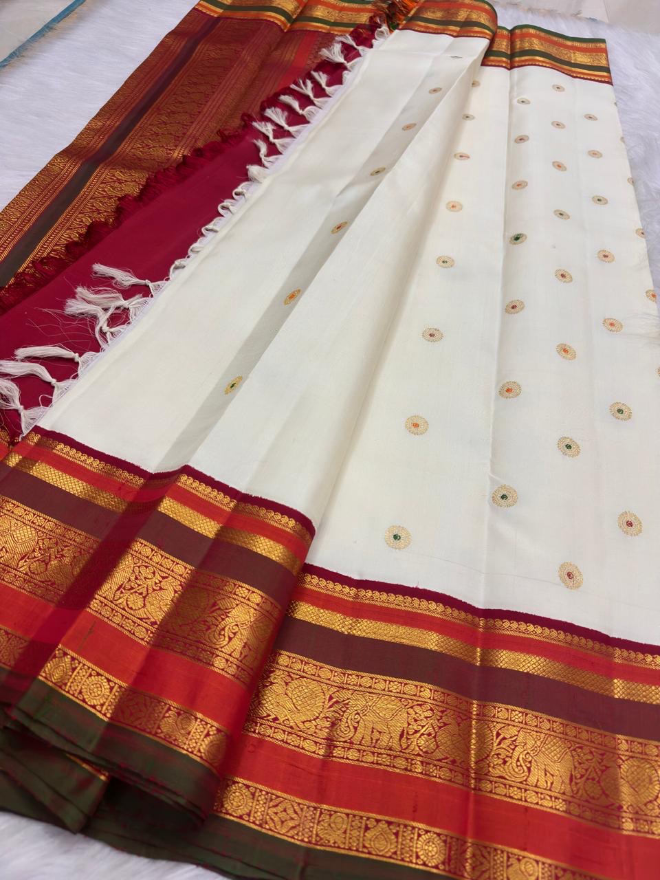 Ivory pure silk Kanchipuram saree, ornamental pallu full view with warm ivory with arakku-red, vermilion and manthulir-green accents