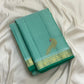 Folded aqua green Kanchipuram silk saree showing handwoven gold zari mayil butta and floral zari border