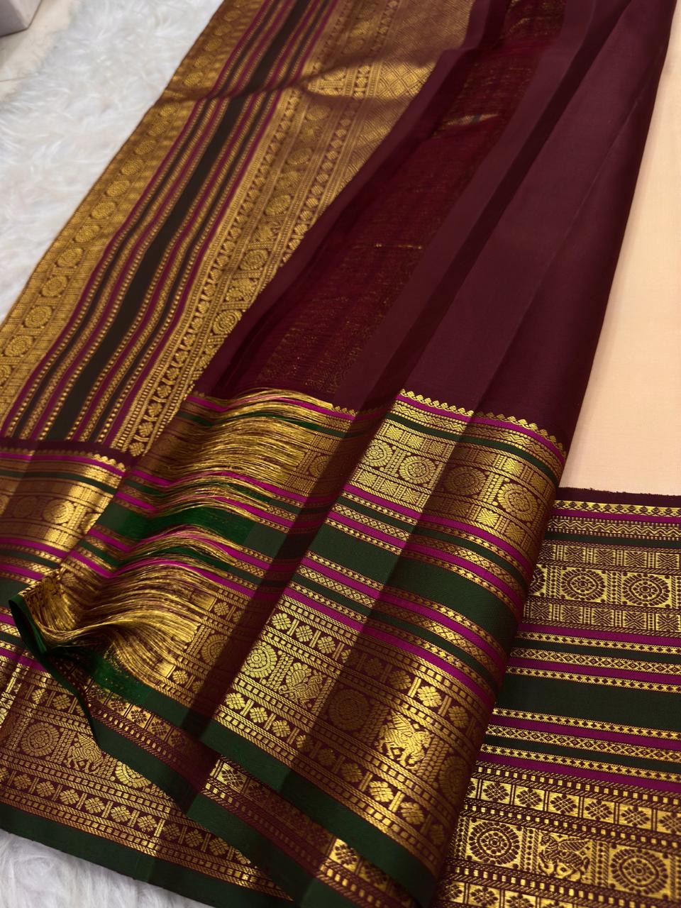 Soft peach ivory Kanchi Pattu saree body with gold buttas.