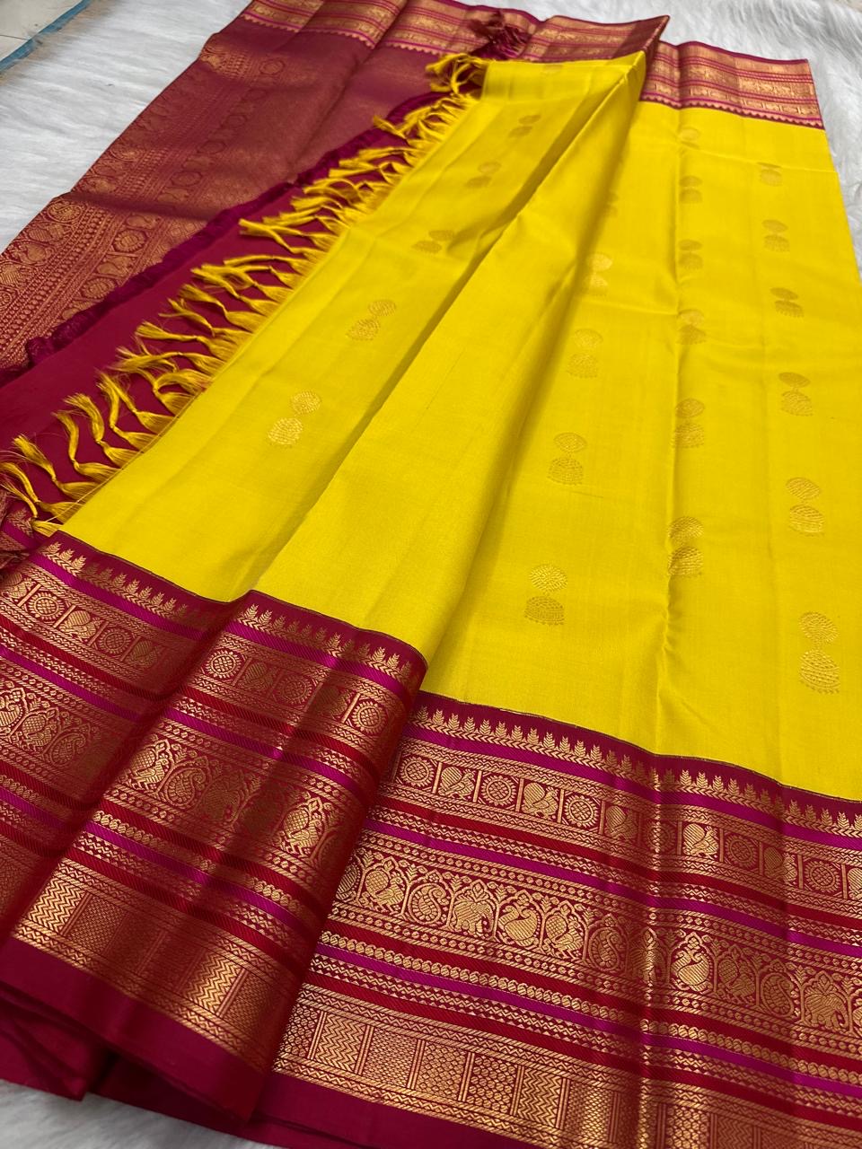 Ornate pallu and border of Turmeric Yellow & Arakku Red Varisaipet Kanchipuram silk saree with traditional zari and silk-thread work.