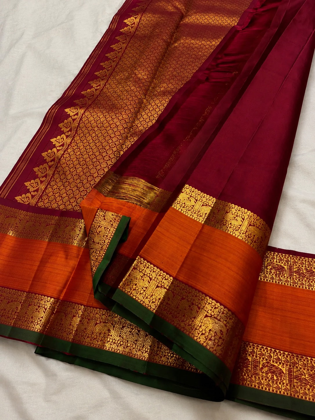 Warm ivory Kanchipuram saree opened to show zari twin bird buttas and rich contrasting border.
