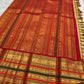 Sandalwood ivory Kanchipuram saree with ornate red zari pallu.