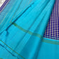 Turquoise and violet checked Kanchipuram pattu silk saree with green selvedge, styled for a New Year family gathering.