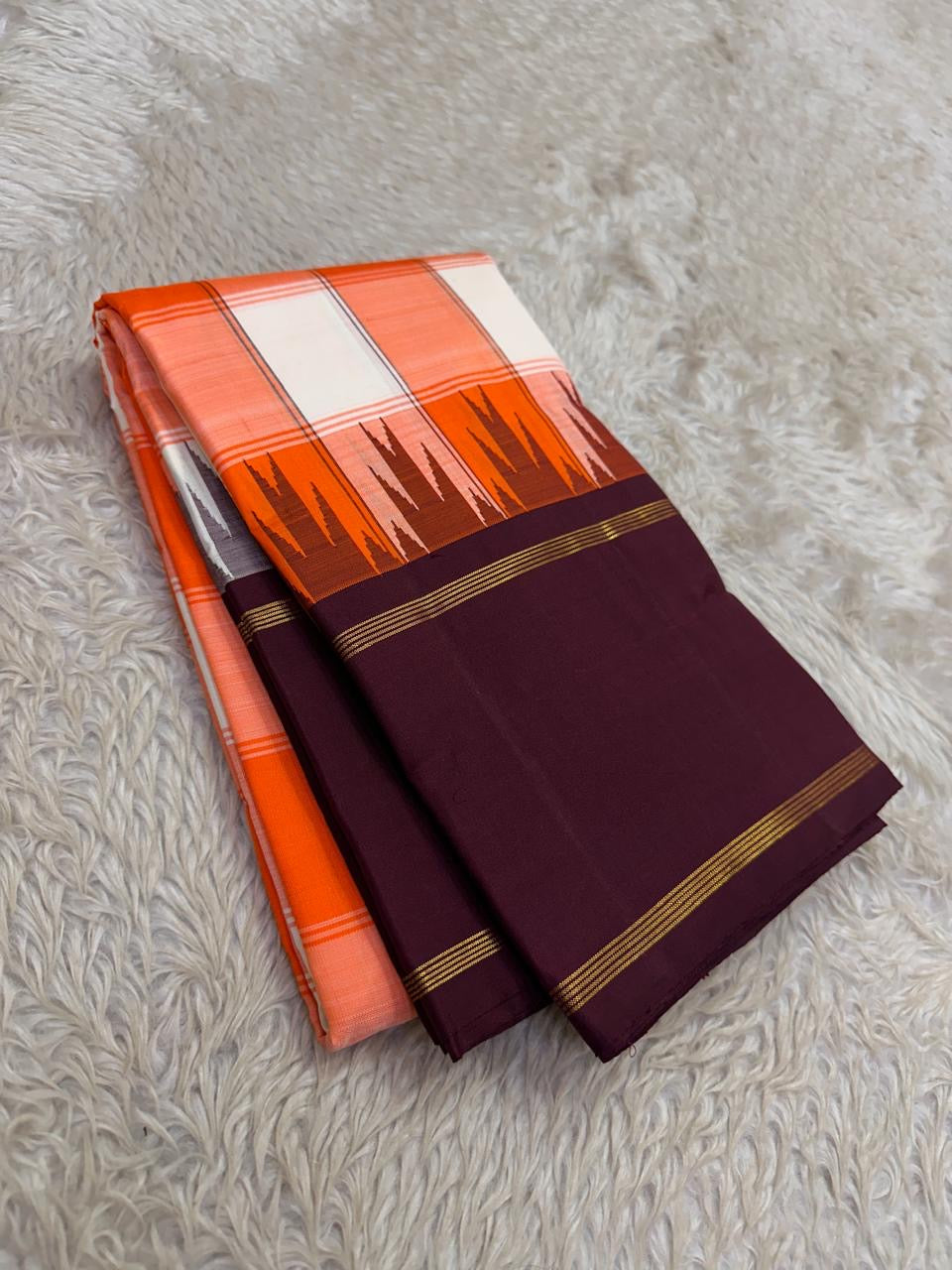 Kesari orange, ivory and coral-pink checked Kanchipuram pattu silk saree with purple border, styled for a sweet sixteen family party.