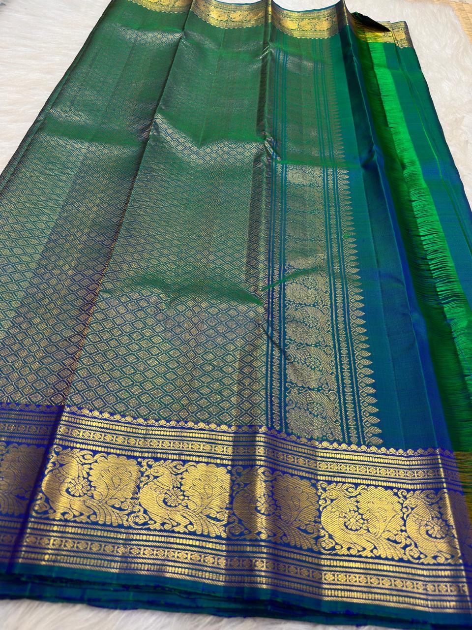 Peacock Blue, emerald green, royal blue and antique gold handwoven Kanchipuram butta silk saree, unfolded full view, with gold zari detailing.