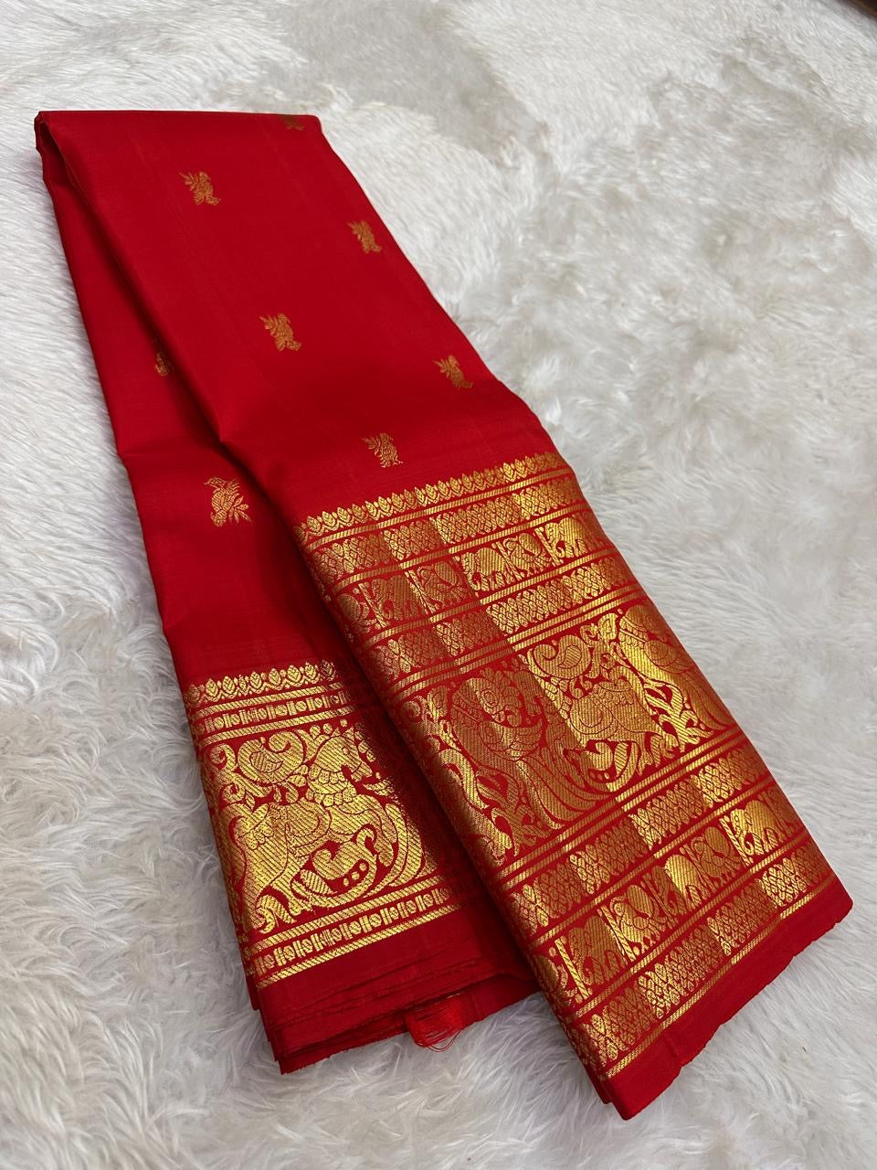 Kanchipattu silk saree in vibrant kumkum red with antique gold border Vanasringaram weave traditional zari detail