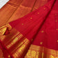 Vermilion red, warm Arakku-red undertones and rich yellow gold handwoven Kanchipuram butta silk saree, unfolded full view, with gold zari detailing.