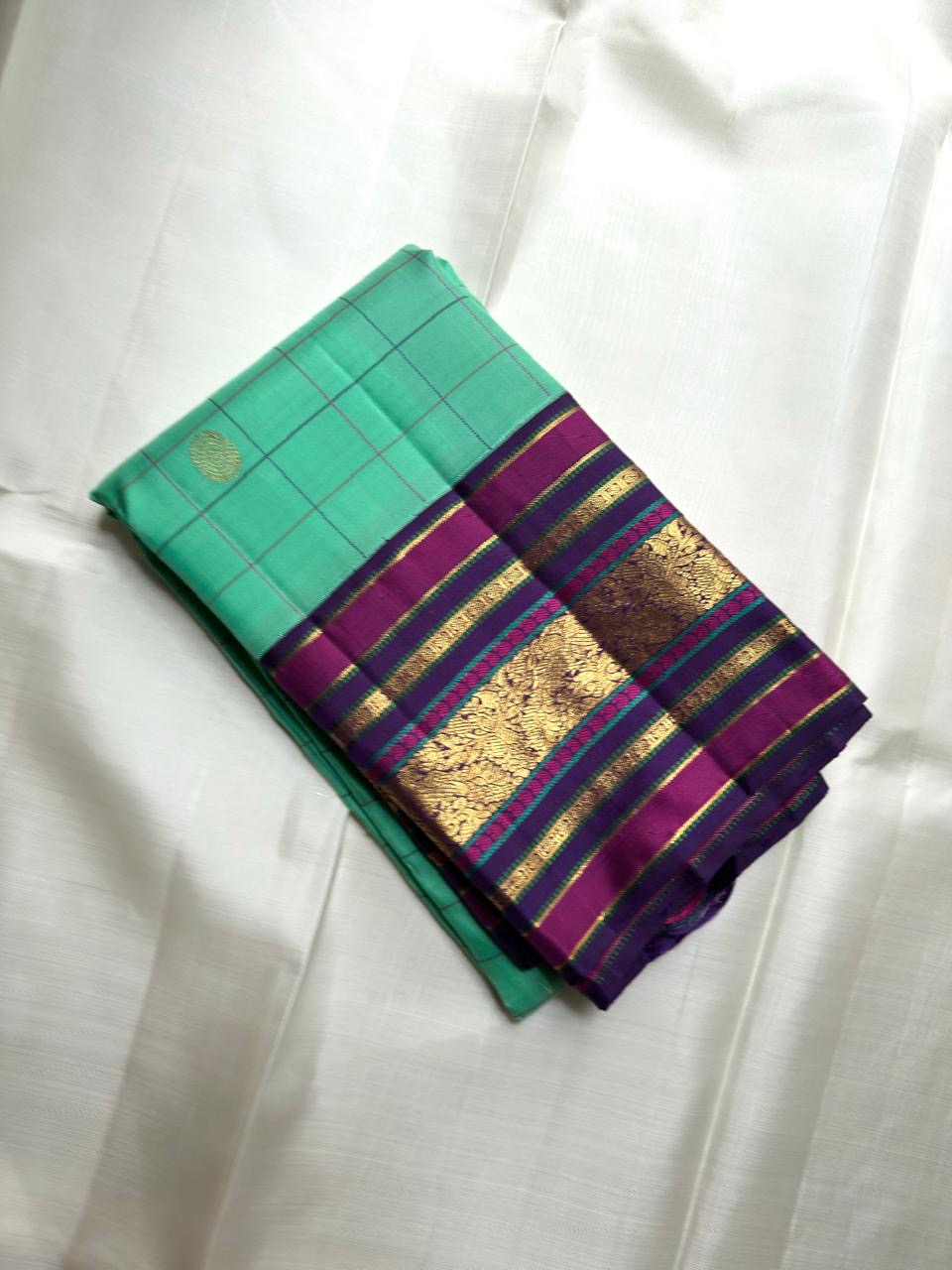 Kanchipuram silk saree in luminous aqua with kanchi kattam checks and plum varisaipet zari border folded view