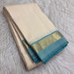 Warm ivory Pure Kanchipuram Silk saree with Firozi blue narrow border and softly gleaming gold-toned zari pallu