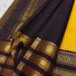 Folded mustard checked Kanchipuram silk saree with deep navy and antique gold zari border, placed on a woven mat.