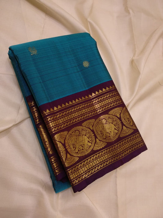 Ocean blue Kanjivaram saree with peacock buttas and wine purple zari border detail