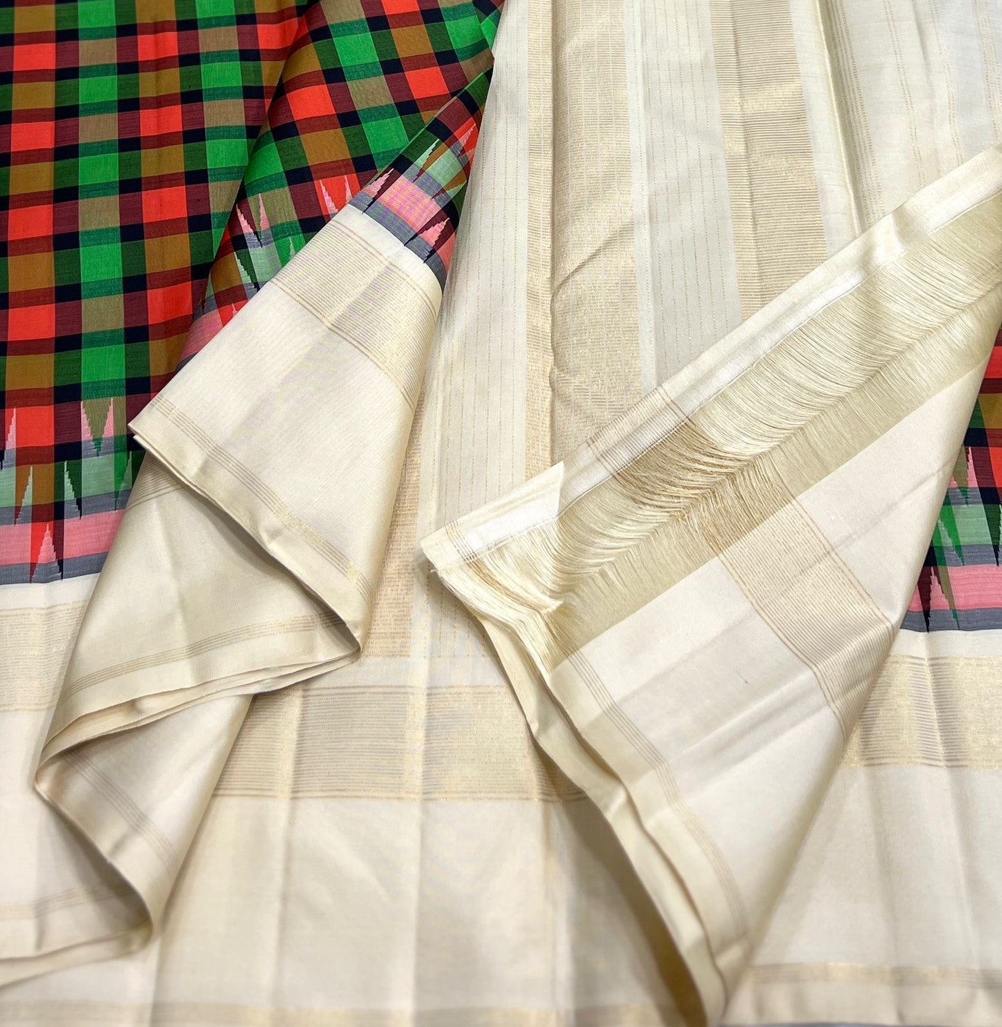 kanchipuram silk saree folded with green grid and coral accents