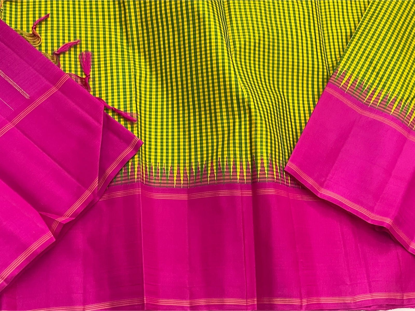 Detail of magenta pallu with fine vertical lines and a contrasting woven panel next to green-yellow checked body
