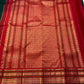 Close-up of chili red varisaipet border and gold zari pallu detail on deep green Kanchipuram silk saree — Idam Living