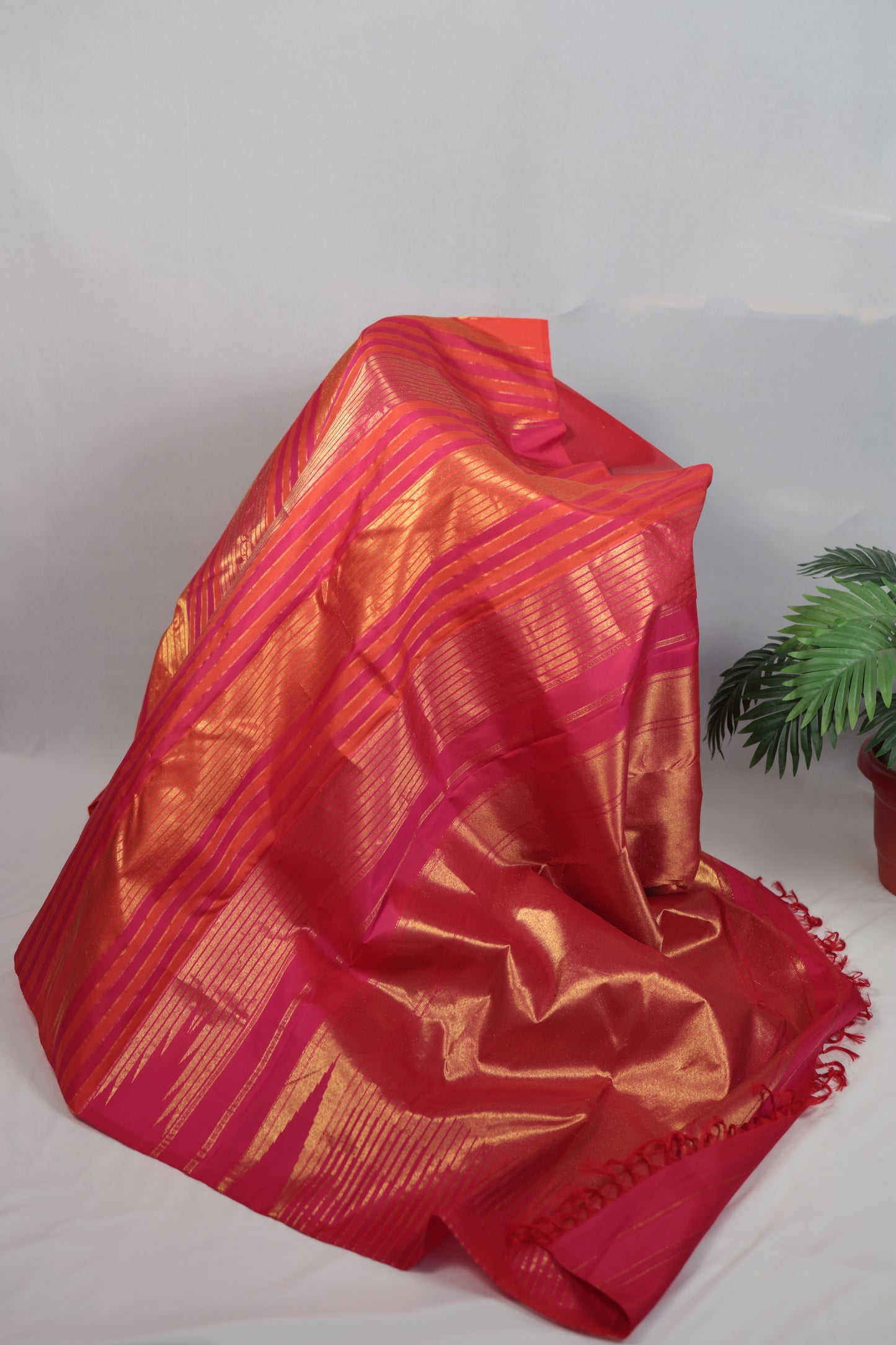 Pure Kanchipuram silk saree with Ettukol weaving and antique gold zari details, draped on a mannequin showing the structured silk body and traditional South Indian craftsmanship