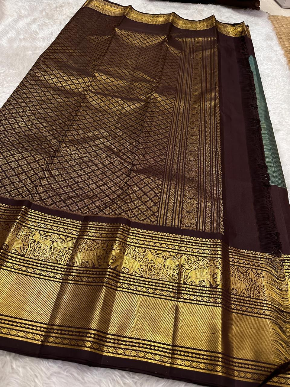 Folded green and brown Kanchipuram silk saree with classic zari work