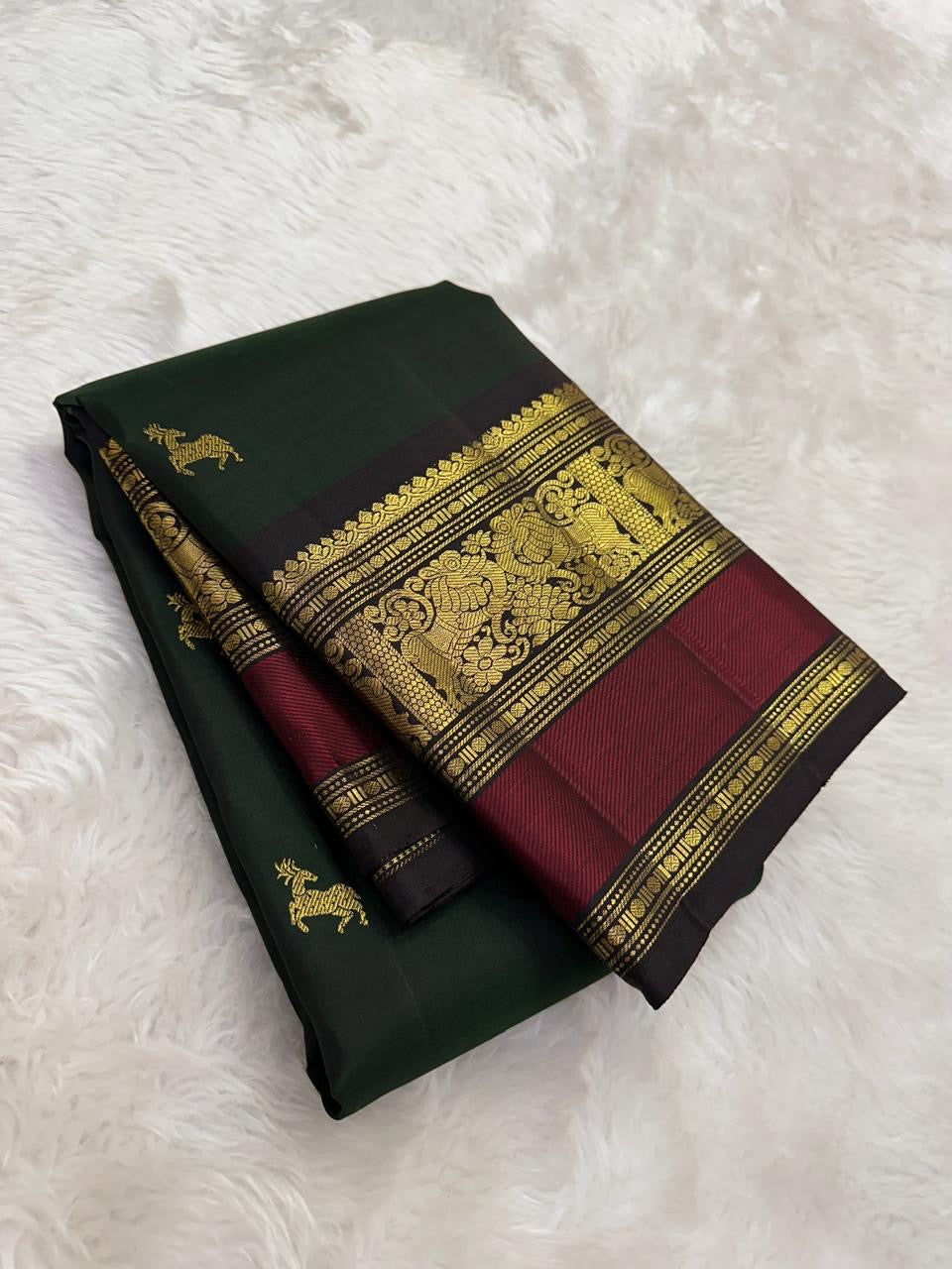 Deep green Kanchipuram silk saree with mahogany red border folded view