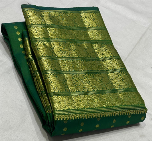 Green Kanjivaram silk saree draped view showing intricate gold border and dotted zari motifs