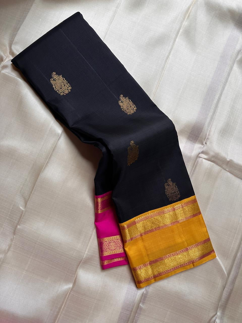 Navy blue pure Kanchipuram silk saree with antique gold zari buttas and Ganga Jamuna mustard and pink border