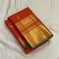 folded vermillion orange kanchipuram silk saree with gold zari border