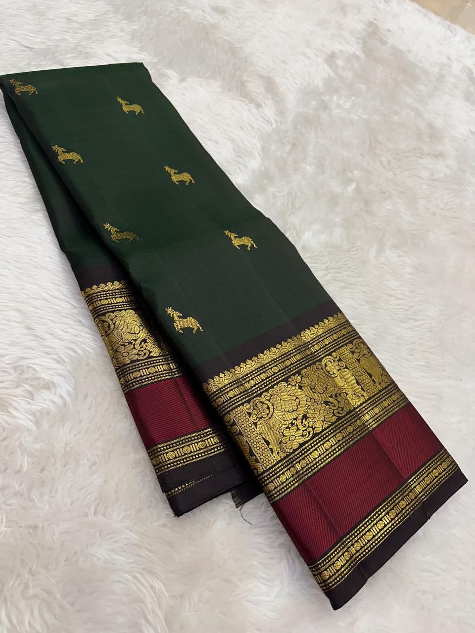 Deep green silk saree with gold buttas and red border draped view
