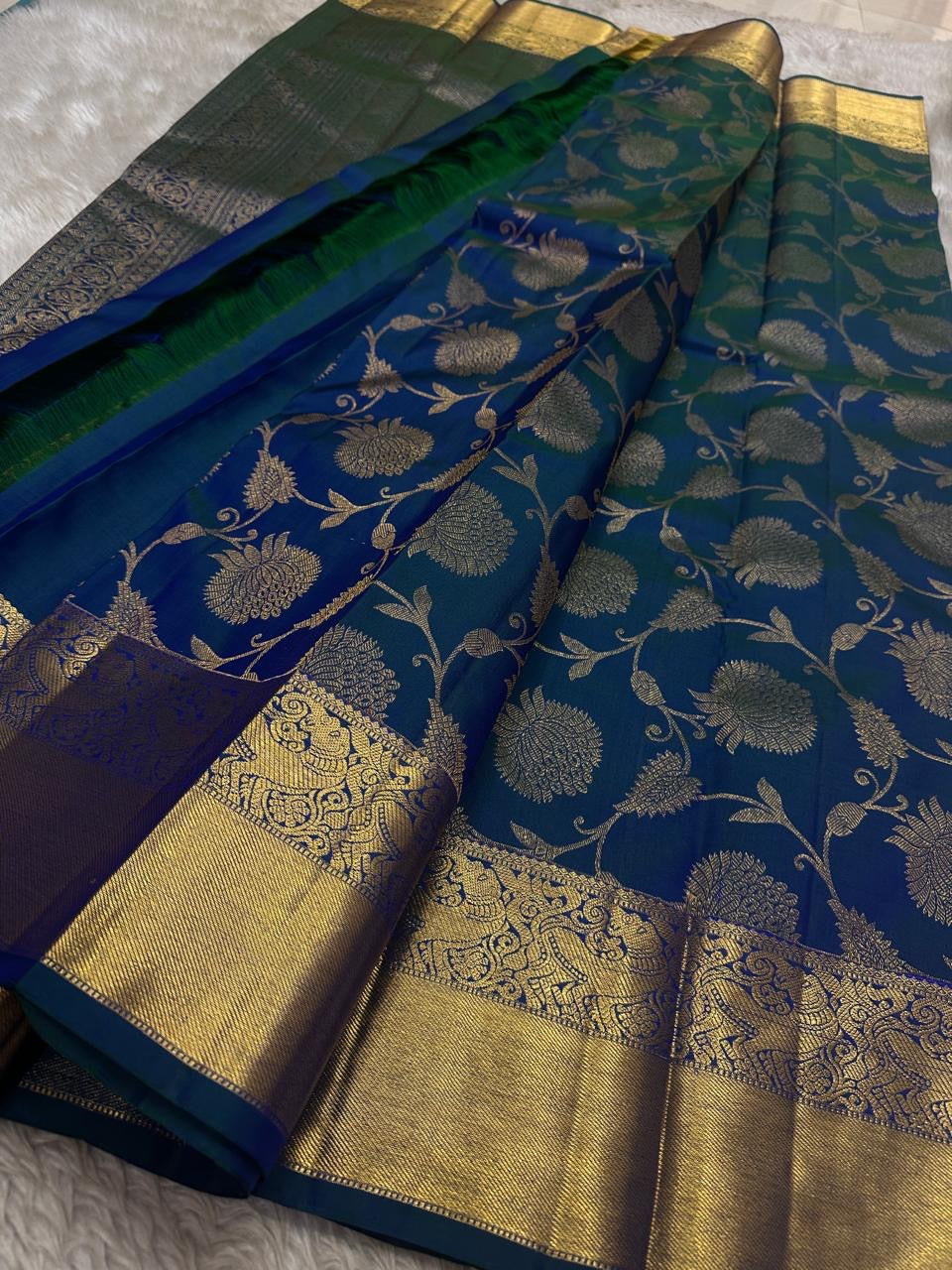 Blue Kanchipattu silk saree with floral butta jaal design folded display view