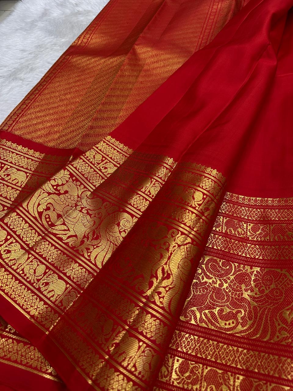 Kanchipattu silk saree in vibrant kumkum red with antique gold border Vanasringaram weave traditional zari detail