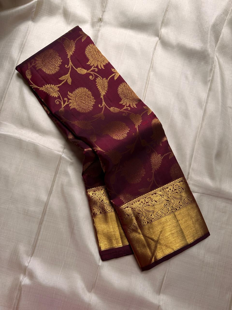 Maroon Kancheepuram silk saree featuring floral jaal pattern with gold zari detail