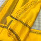 Mustard pallu of Kanchipuram silk saree with striped weave, tassels, and black zari woven border detail
Full mustard pallu laid flat with fine striped weave and zari woven edge, available in the USA