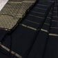 Close view of zari woven pallu section with black tassels and black saree body featuring thin zari stripe borders.