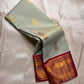 Sage green Pure Kanchipuram silk saree folded lengthwise showing maroon zari woven border panel