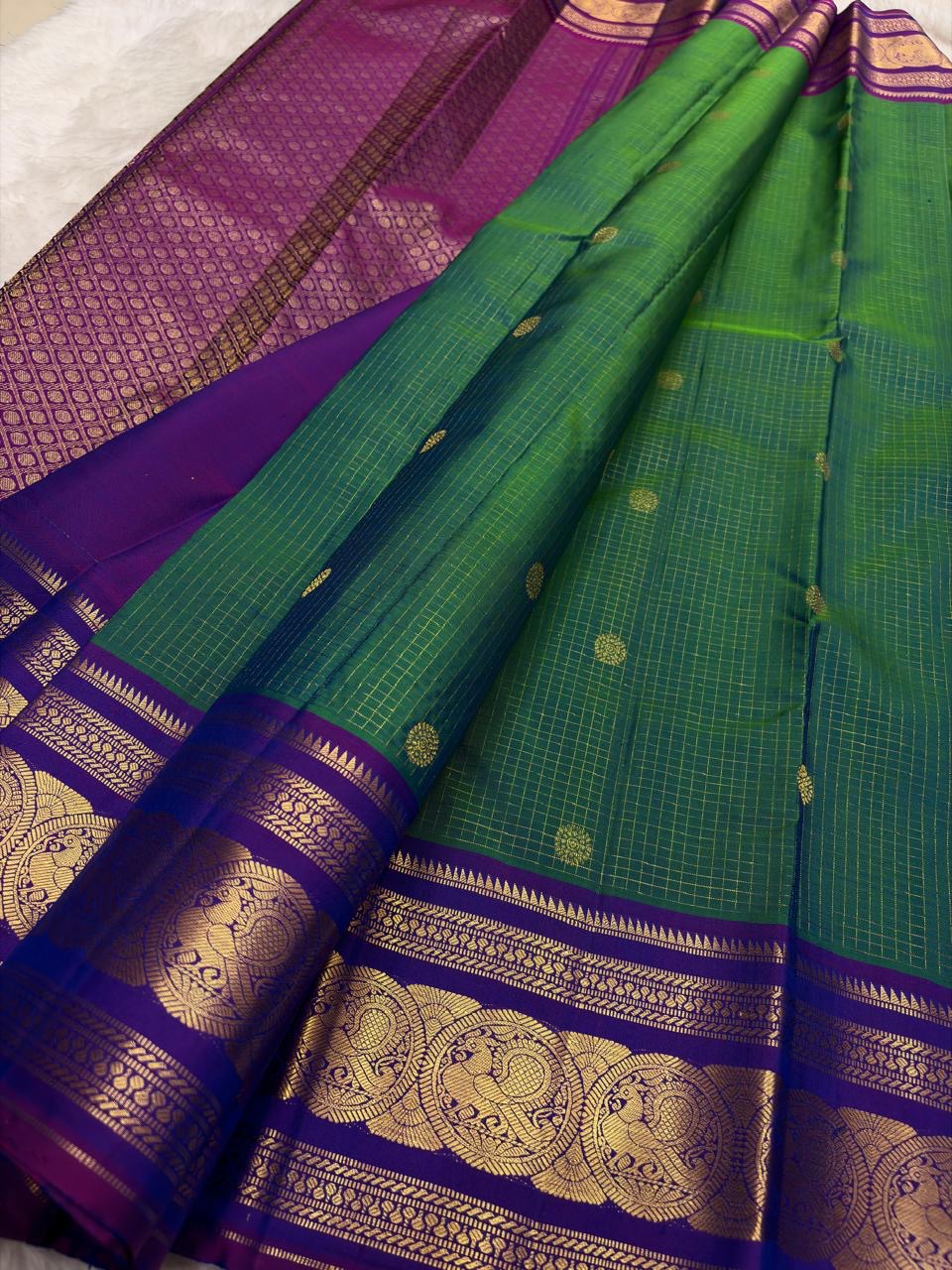 Green Kanchipattu silk saree with sorgavaasal mayil pattern and zari kattam border folded display view