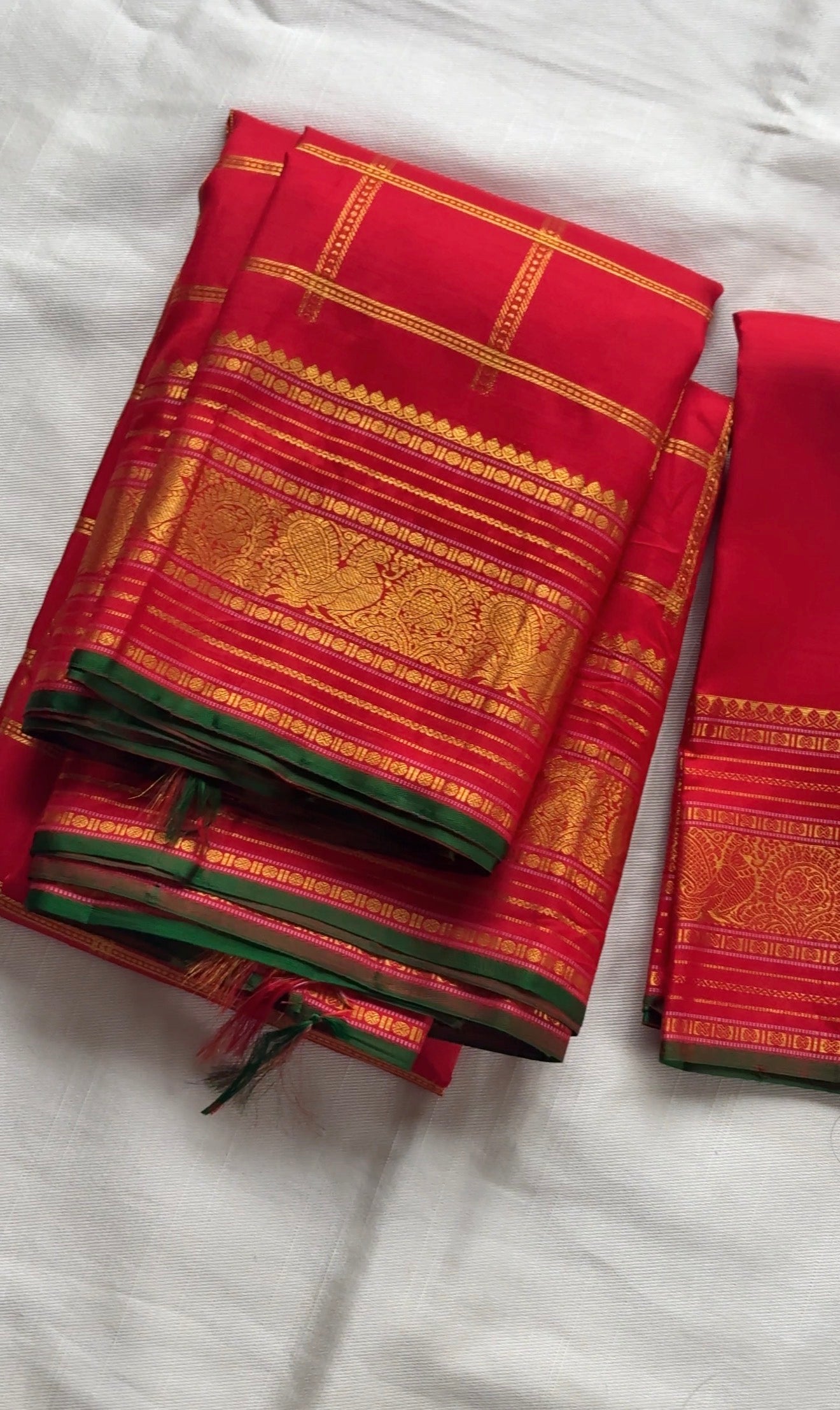 Red Kanjivaram silk saree with traditional mayil butta motifs and bottle green selvedge draped view