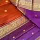 Folded view of rust orange purple Kanchipuram silk saree with intricate vanasringaram animal motifs
