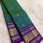 Green Kancheepuram silk saree featuring peacock motifs and zari kattam border with traditional gold zari detail