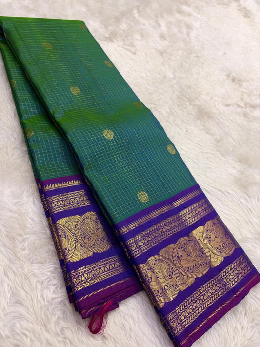 Green Kancheepuram silk saree featuring peacock motifs and zari kattam border with traditional gold zari detail