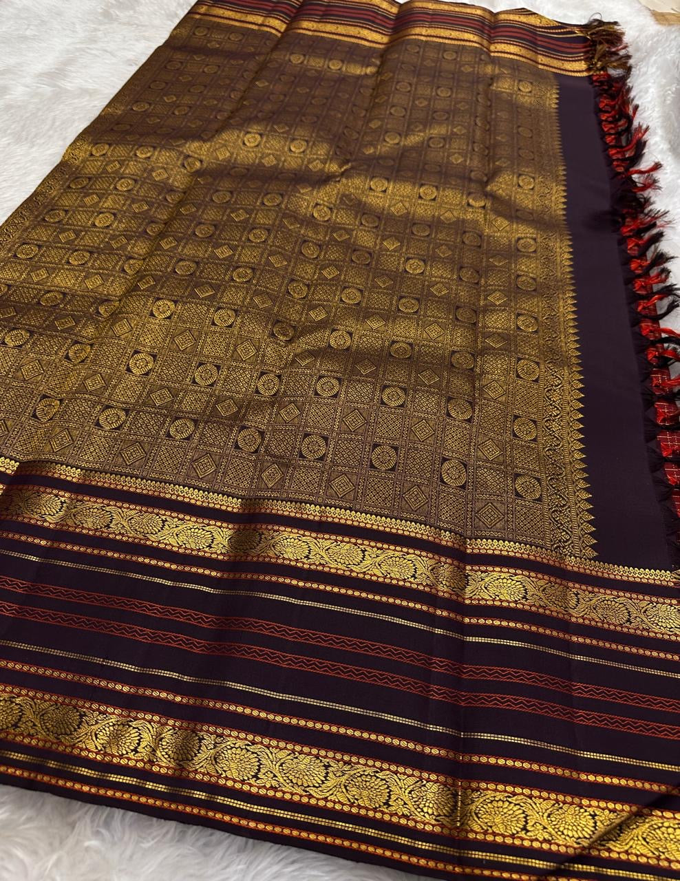 Kanchipattu silk saree gold motif pallu close up with rich red silk base