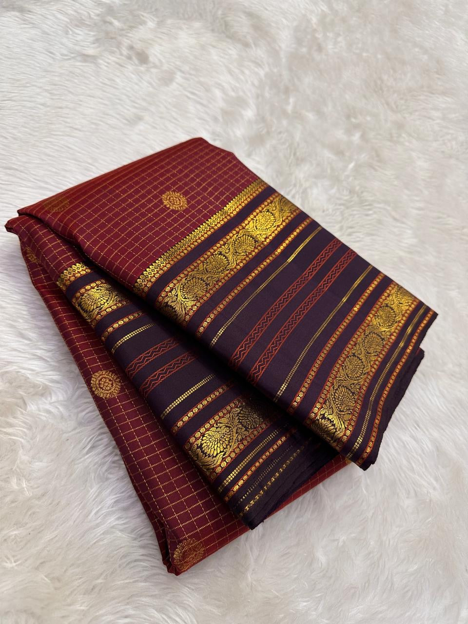 Kanjivaram silk saree ruby red body with gold zari motifs and varisaipet border folded view