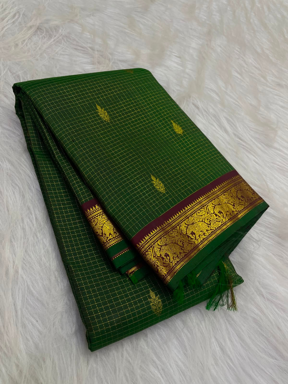 Yaanai (elephant) motif detail on maroon zari border, forest-green Kanchipuram saree