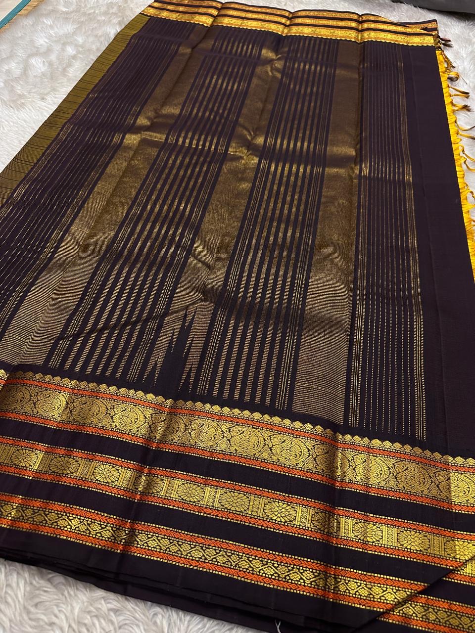 Mustard checked Kanchipuram silk saree with deep navy border and antique gold zari detailing, shown folded lengthwise on a woven mat.
