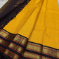 Mustard checked section of a Kanchipuram silk saree paired with a deep navy border and antique gold zari bands, shown partially spread.
