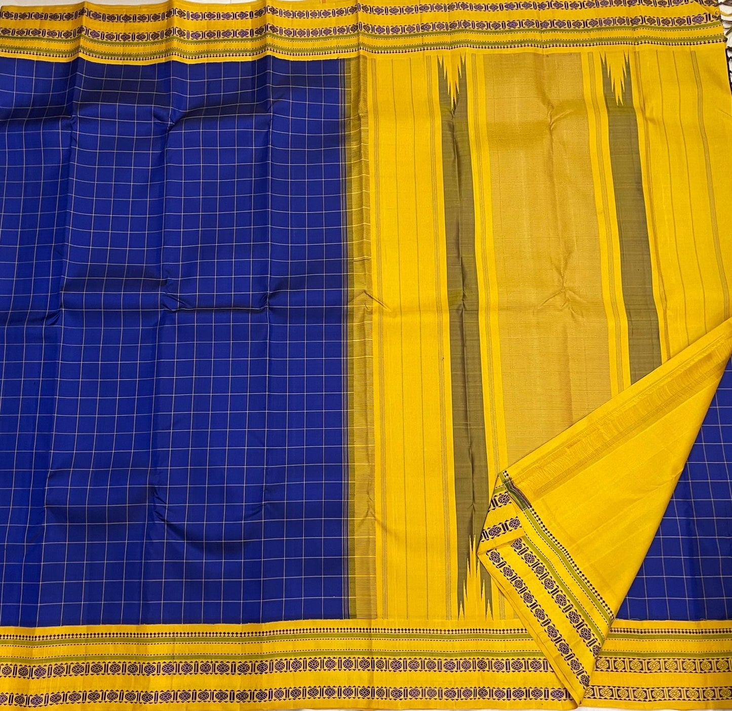 Border close-up of royal blue checked pure Kanchipuram silk saree with mustard yellow border and woven geometric bands