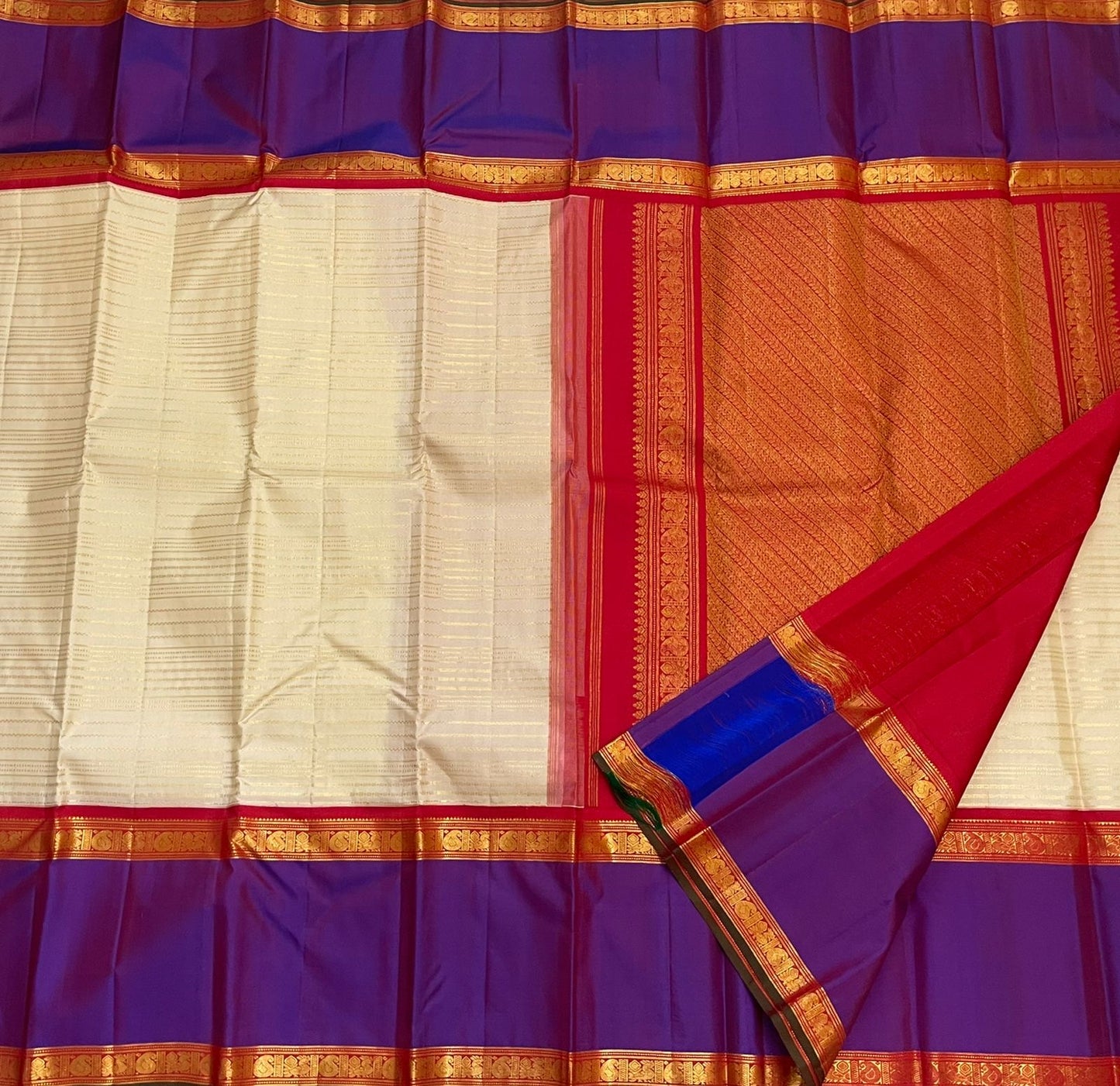 Full spread pure Kanchipuram silk saree with ivory striped body, purple border, and orange zari woven pallu, available in the USA