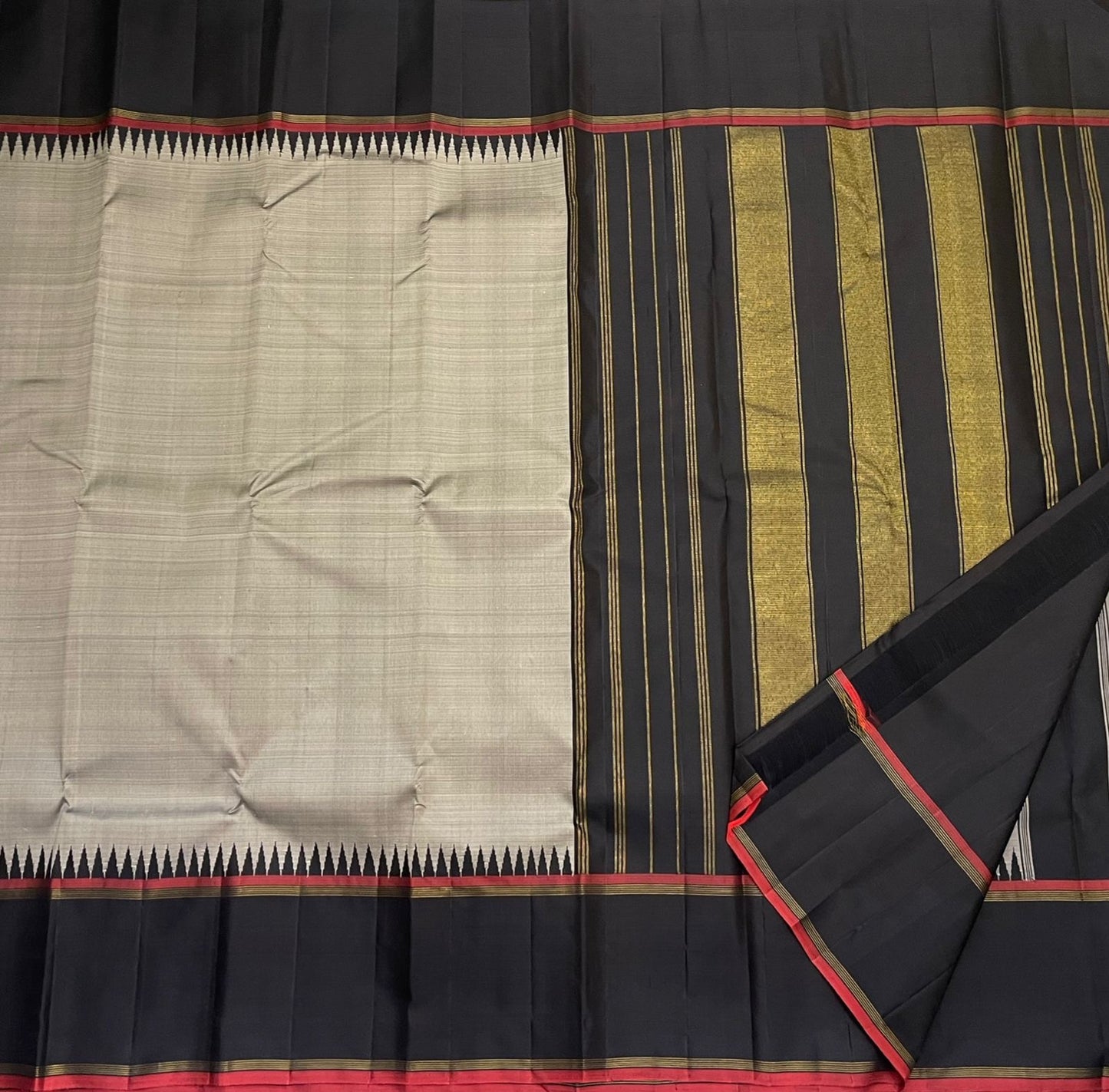 Close view of pillayar reku motif on grey silk with black border and red selvedge, available in the USA.