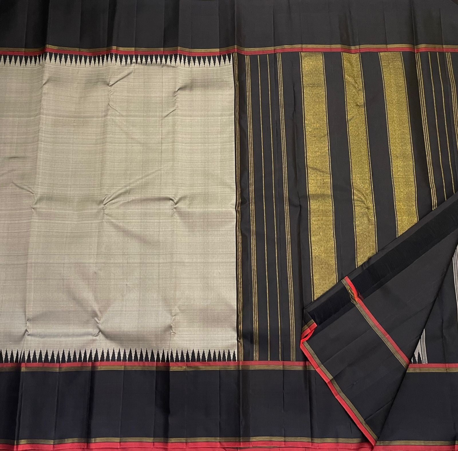 Close view of pillayar reku motif on grey silk with black border and red selvedge, available in the USA.