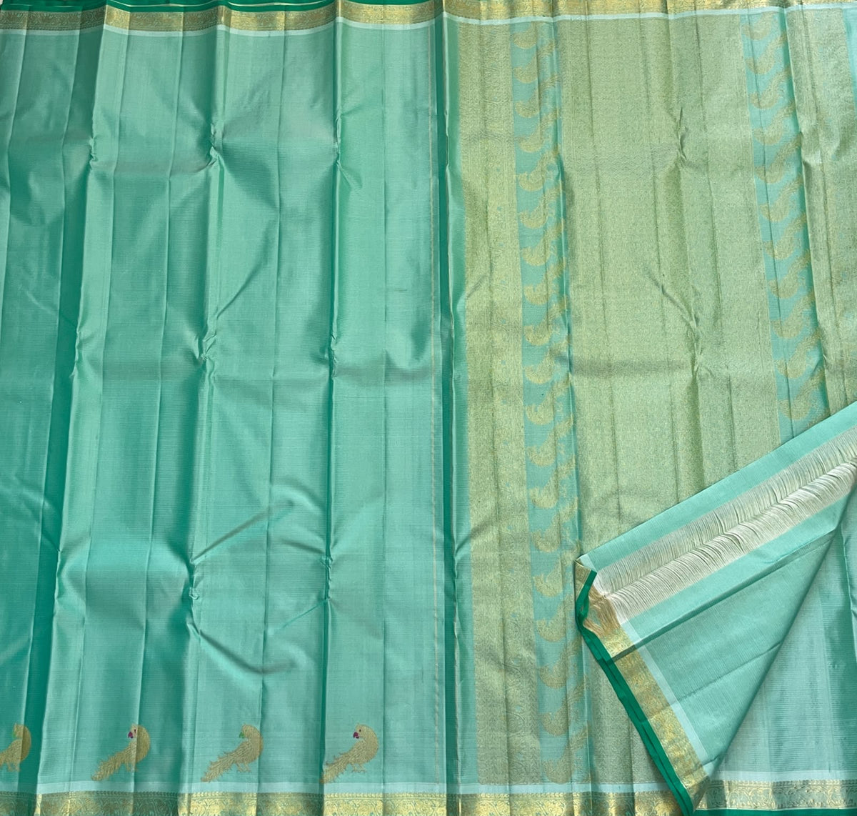 Needle fine Vairaoosi lines across a mint aqua Kanchipuram pure silk saree with a soft natural sheen