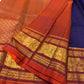 Deep Oodha blue Pure Kanchipuram Silk saree with kesari-orange Sorgavaasal Yaanai border worn at a temple vilakku puja