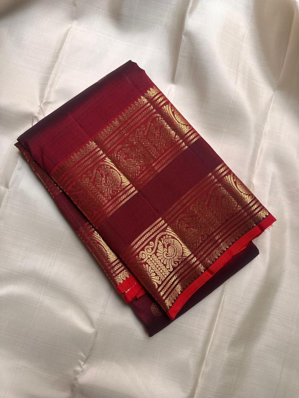 Twin peacock antique-gold Rettapet border bands with fine red selvedge on deep arakku maroon Kanchipuram silk saree